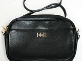 un sac à bandoulière noir sur lequel figure la lettre « h »