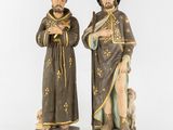 a pair of statues of a man and a woman with a dog