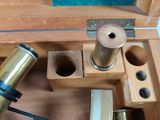 a wooden box with a telescope and other items in it