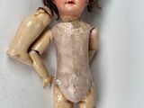 a doll that is standing on a white surface