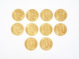 several gold coins arranged in the shape of a heart on a white surface