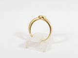 an image of a gold ring sitting on top of a white marble block