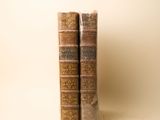 deux vieux livres posés l'un sur l'autre sur une table