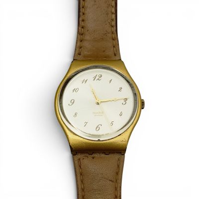 une montre en or avec un cadran blanc et un bracelet en cuir marron