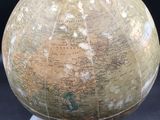 a large globe with a clock on top of it