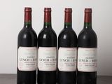five bottles of wine are lined up on a wooden table