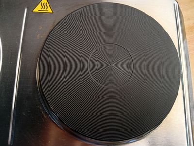 une photo d'une plaque de cuisson sur laquelle se trouve un brûleur noir