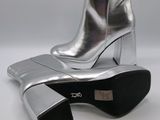 pair of silver boots with black soles on a white surface