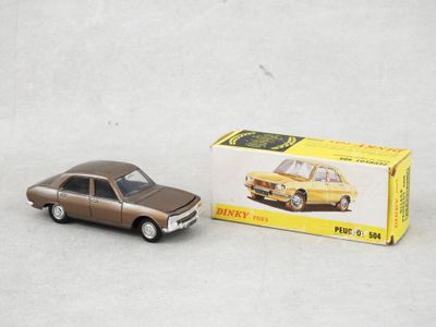 La petite voiture se trouve à côté de la boîte, sur la table.