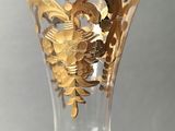 a glass vase with a gold design on it