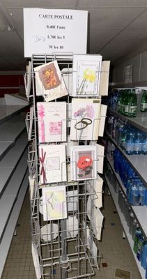 un présentoir métallique contenant de nombreux articles dans un magasin