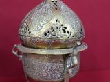 an ornate silver plate with a domed lid on a red background