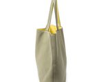the small leather tote bag is grey and has a yellow handle
