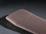 a pink object on a black surface next to a black object