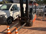 une camionnette blanche garée sur un parking délimité par des cônes orange