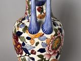 a vase with a blue handle on it on a table