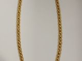 gros plan d'un collier en chaîne en or sur fond blanc