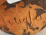 a brown and black vase with a tag on it