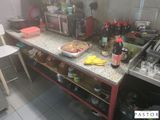 une cuisine équipée d'une cuisinière, d'un évier, d'un micro-ondes et d'un plan de travail