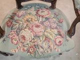 a chair that has a floral upholstered seat on it