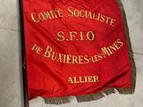 une banderole rouge et dorée posée par terre à côté d'une paire de ciseaux