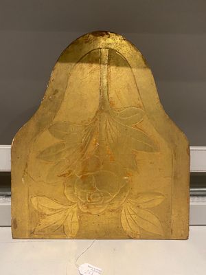 a gold plate with a flower design on it on a table