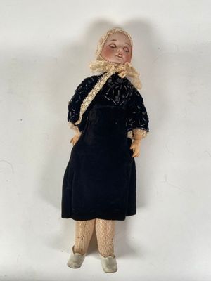 an old fashioned doll is posed on a white surface