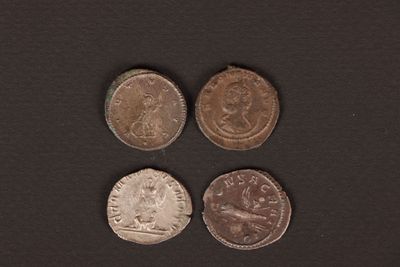 four different types of coins on a black surface
