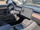 a car dashboard with a laptop on it and a car in the background