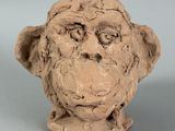 a clay sculpture of a monkey head on a table