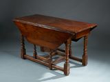 an antique oak drop leaf table with turned legs and turned top