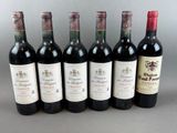 six bottles of wine are lined up in a row on a table