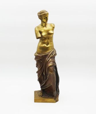 a bronze statue of a woman standing on a marble base