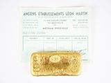 a gold bar sitting next to a receipt on a table