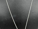 a silver necklace with a cross pendant on a mannequin mannequin