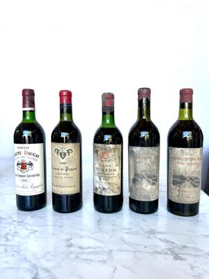 several bottles of wine are lined up on a marble table