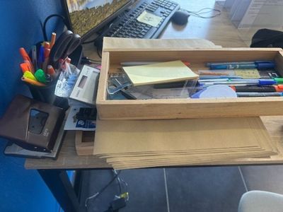 a desk with a computer, keyboard, mouse, and other office supplies on it