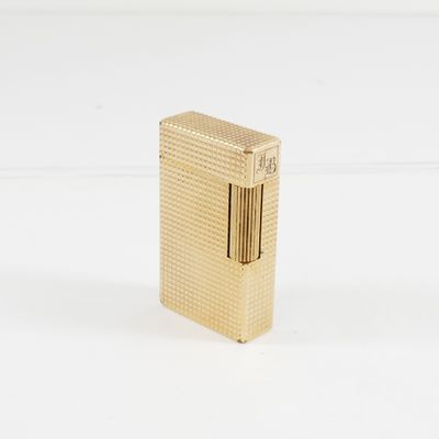briquet plaqué or posé sur une surface blanche, avec un fond blanc