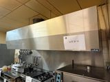 une affiche accrochée au mur au-dessus d'une cuisinière dans une cuisine