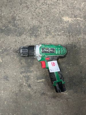 a cordless drill that is laying on the ground