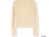 a white sweater hanging on a hanger on a white wall