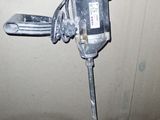 a drill on the ground next to a pipe in a room