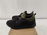 a pair of black and green sneakers sitting on top of a cardboard box