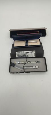a pen and a pencil in a box on a table