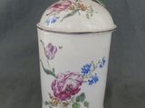 a white container with flowers on it on a table