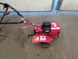 a small red machine that is sitting on the ground