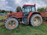 un tracteur rouge garé dans l'herbe