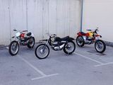 three motorcycles parked in a parking lot next to a building