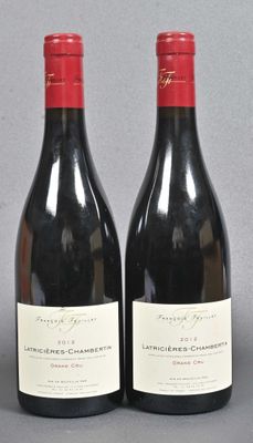 two bottles of red wine sitting next to each other on a table