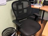 a black office chair sitting in front of a computer desk